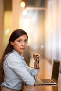 serious attractive woman working on laptop in cafe